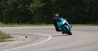 A motorcyclist leaning hard into a sharp curve on a sportbike