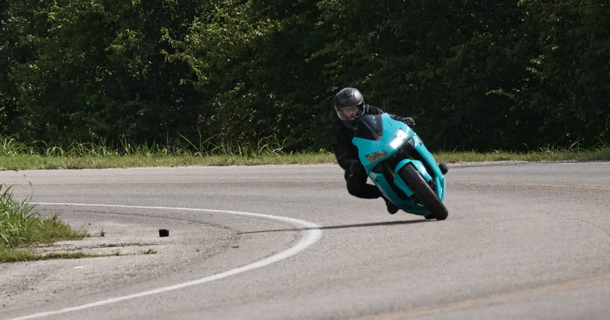 A motorcyclist leaning hard into a sharp curve on a sportbike